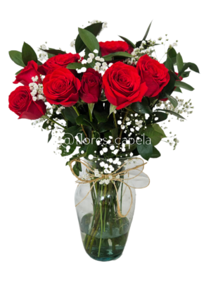 Rosas acompañadas con follaje de gypsofilia y ruscus en florero