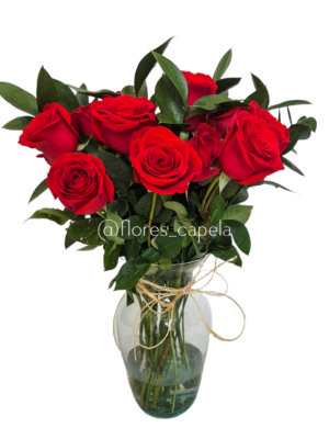 Rosas acompañadas con follaje de ruscus en florero