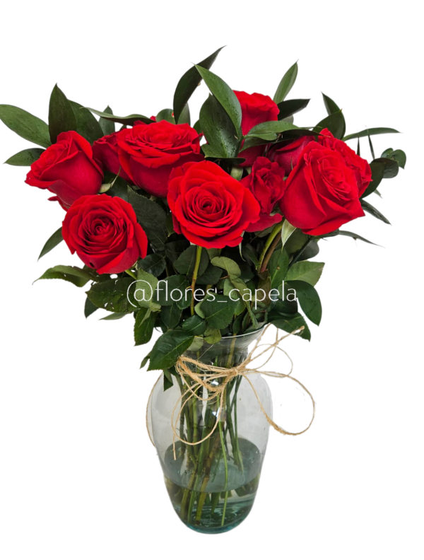 Rosas acompañadas con follaje de ruscus en florero